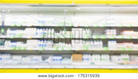 Defocused blur of supermarket shelves with dairy products. Blur background with bokeh. Defocused image