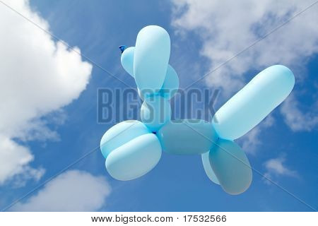 Ballon con forma di caniche cane barboncino volando in giornata di sole cielo azzurro