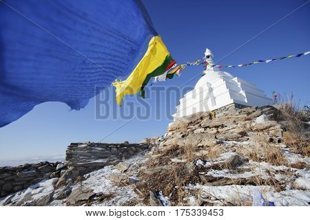 White Buddhist stupa with colorful flags. Ogoi island. Baikal landmark. Russia