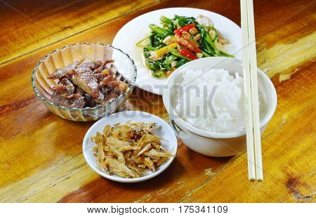 boiled rice eat with fried anchovy and morning glory on table