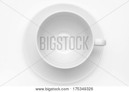 Empty white cup with sauser on white background. High angle