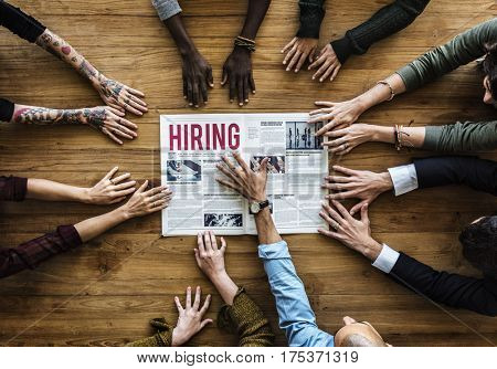 Diverse People Hands Reach Out for Hiring Newspaper Announcement