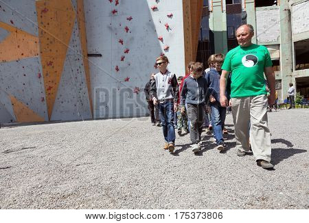 Group of Junior athletes led by Coach at opening of Climbing Championship. Dnipro, Ukraine, May 20, 2016