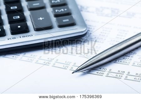 Caclulator and Pen on the Document - Close Up