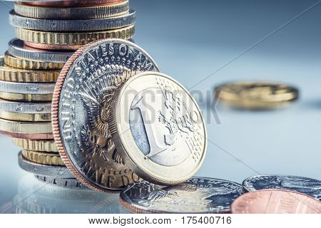 Euro and US Dollar coins. One Euro and USA Dollar coins standing on edge supported on coins.