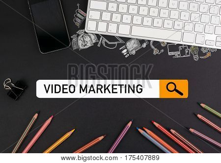 video marketing concept. colorful pencils and a computer keyboard with a mobile phone on a black table.