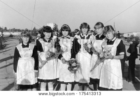 SENNO BELARUS - SEPTEMBER 1 1985: Schoolgirls-tenth graders in elegant school uniform with bouquets of flowers on September 1st (1985) Senno Belarus