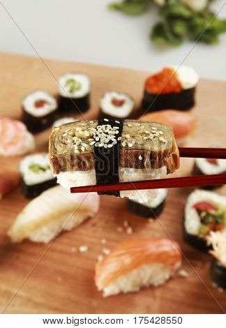Chopsticks with Nigri Sushi and Sushi Plate in Background