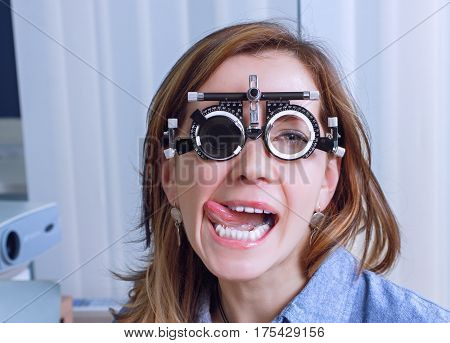 Girl woman in messbrille glasses in ophthalmology clinic. Ophthalmic glasses for diopter detection.