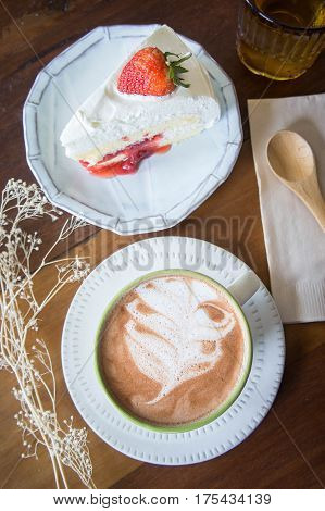 coffee cup and delicious cake strawberry and relax time moblie on table in coffee shop