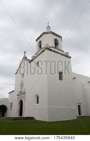 A historic white stucco Spanish mission church at Goliad State Park and Historic Site in Goliad Texas.