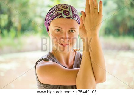 Woman practicing yoga - garudasana pose in park
