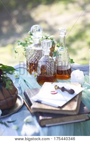 Cocolate cake decorated with flowers and three whiskey decanters against a light gray background with copy space