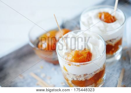 Oats layered with spicy and sweet apricot jam and cream served for breakfast. Healthy food concept.