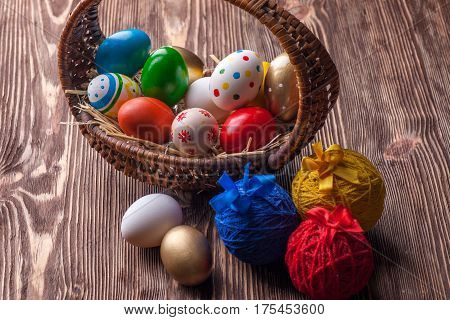 Colorful easter edds in basket on a brown wooden table