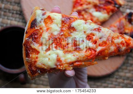 A slice of hot pizza just from the oven with melted cheese