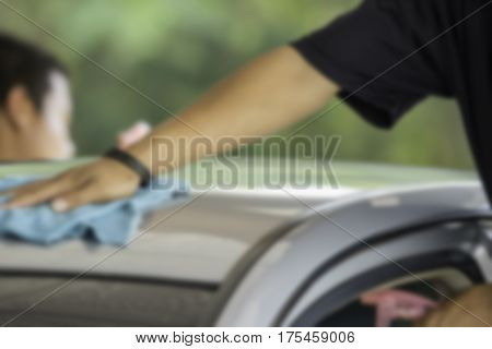 Blurry image Man was wiping car roof with hand and microfiber cloth Car cleaning Car washing