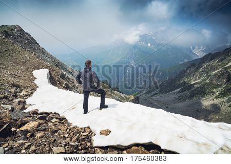 Hiker Stays On A Snow Mountain Hill