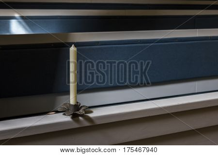 Dornburg Germany - July 23 2016: Candle on a blue church bench in a church in Dornburg Saale Germany.