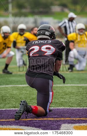 Football player taking a knee during an injury time out.
