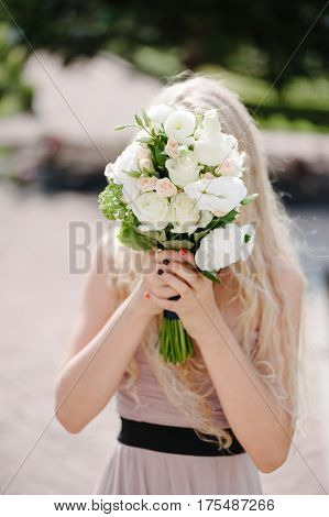 Bride holding delicate and tender marriage bouquet in white and green colours