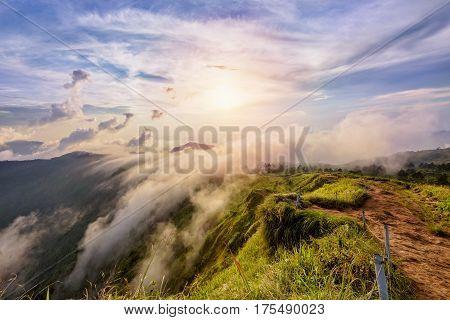 Beautiful landscape nature on peak mountain with sun cloud fog and bright colors of sky and sunlight during sunset in winter at viewpoint Phu Chi Fa Forest Park in Chiang Rai Province Thailand