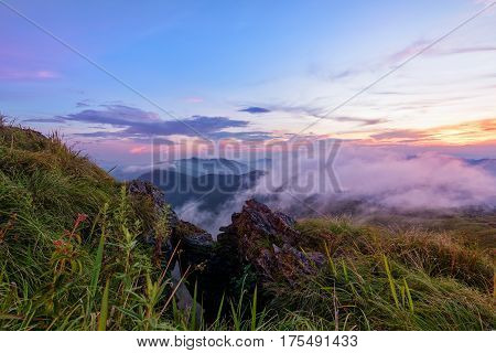 Beautiful landscape nature on peak mountain with sun cloud fog and bright colors of sky and sunlight during sunset in winter at viewpoint Phu Chi Fa Forest Park in Chiang Rai Province Thailand
