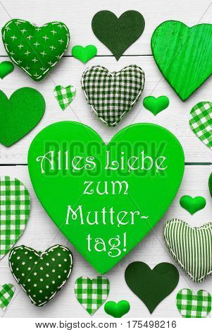 Green Vertical Heart Texture With German Text Alles Liebe Zum Muttertag Means Happy Mothers Day. White Wooden Background. Textile Hearts Which Are Dotted and Striped. Greeting Card For Congratulations
