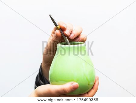 Unrecognizable woman drinking yerba mate from ceramic cup.