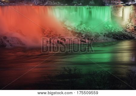 Night scene of Niagara Falls USA american beautifully illuminated in red green and yellow winter scene with snow ice and frost