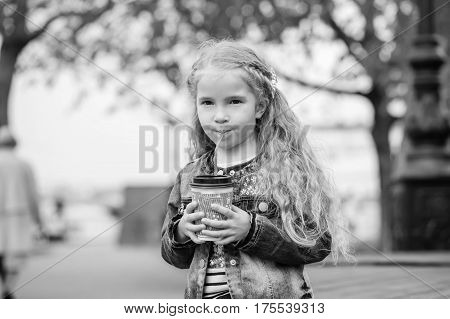 Little happy girl drinking cocoa out of the straw ( black and white )