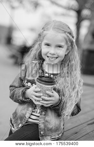 Little happy girl drinking cocoa out of the straw ( black and white )