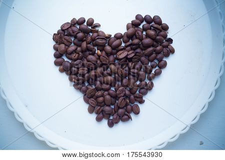 Coffee Beans In Form Of Heart On Beautifull Background. Love. Insparation. On White Plate.