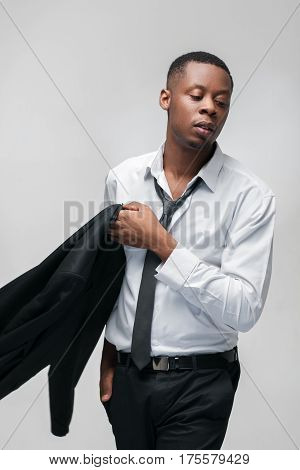 Fashion clothes, brand jackets, expensive men suits. African american guy in office dress code on grey background.
