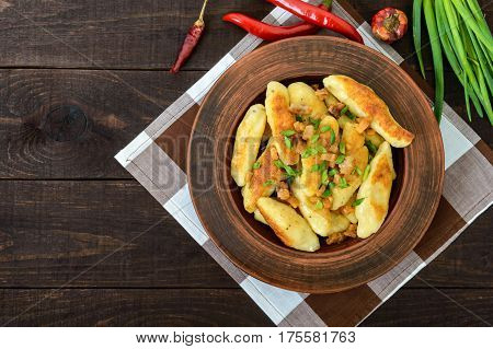 Popular traditional Czech Hungarian German dish: potato knedli (dumplings) with slices of fried bacon spicy red pepper and green onions. The top view