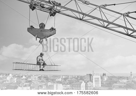 Perfect lunch. Monochrome shot of a shirtless retro builder enjoying peaceful lunch sitting on a crossbar high above the city construction crane building vintage black and white concept copyspace
