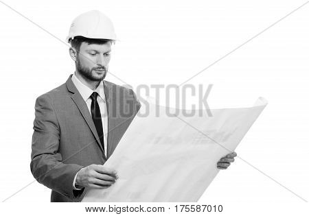 Professional architect. Black and white shot of serious bearded male architect in hardhat examining architectural blueprints isolated on white. Professional career occupation project new future concept.