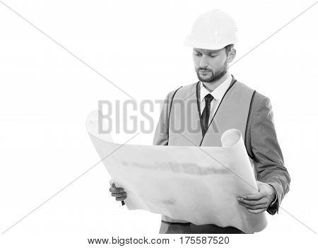 Final check. Black and white shot of a confident successful male constructionist in a hardhat and safety vest looking at the blueprints on white background with copyspace
