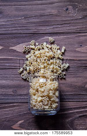 Raw macaroni on an old wooden table. Mix pasta. Background