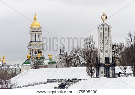 Winter view of Kiev-Pechersk Lavra and Holodomor monument with National Museum 