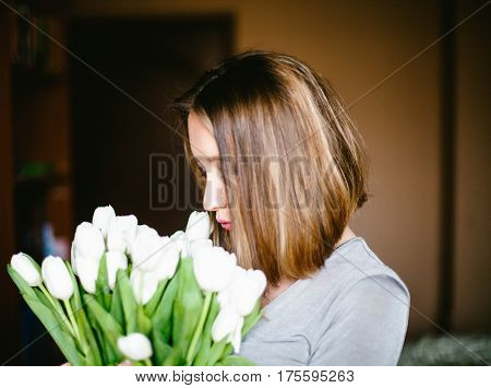 A girl holds a bouquet of white tulips