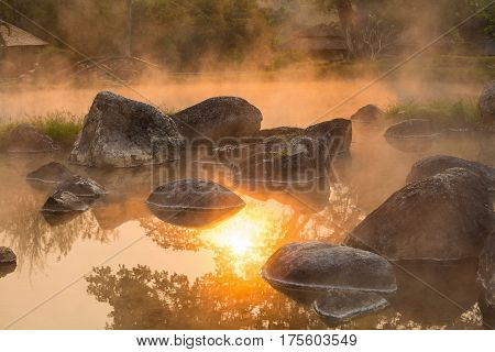 Sun reflecing on the Hot spring at national park during sunrise Thailand