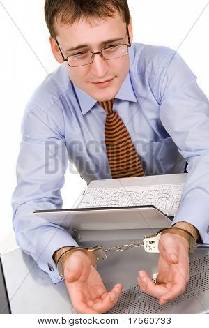 Bonito jovem empresário ligado ao laptop com algemas