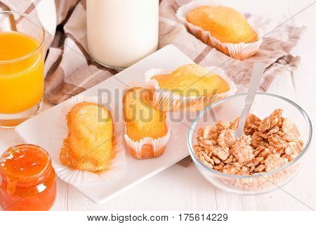 Breakfast with plumcake and orange juice on wooden table.
