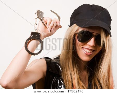 Jeune fille blonde « police » avec des menottes isolé on white