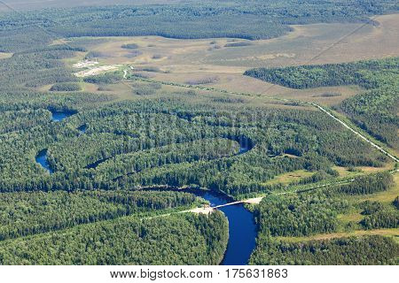 view from above the bridge through the small forest river