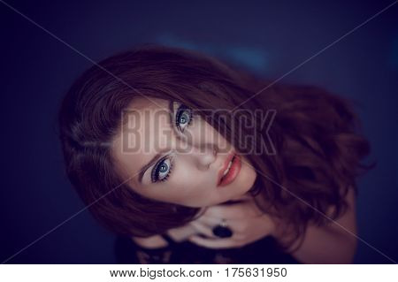 A Studio Portrait Of A Young Woman With Long And Wavy Hair And B