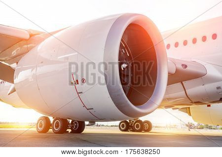 Large modern aircraft view of the huge engine and chassis the light of the sun.