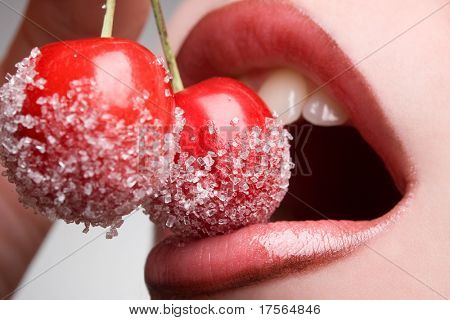 mladá žena ústa s červených třešní pokryté cukru