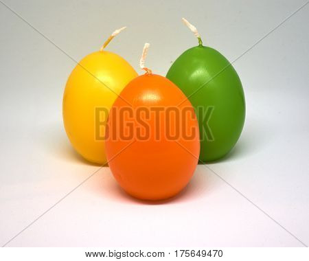 Easter candle in egg form on a white background isolated
